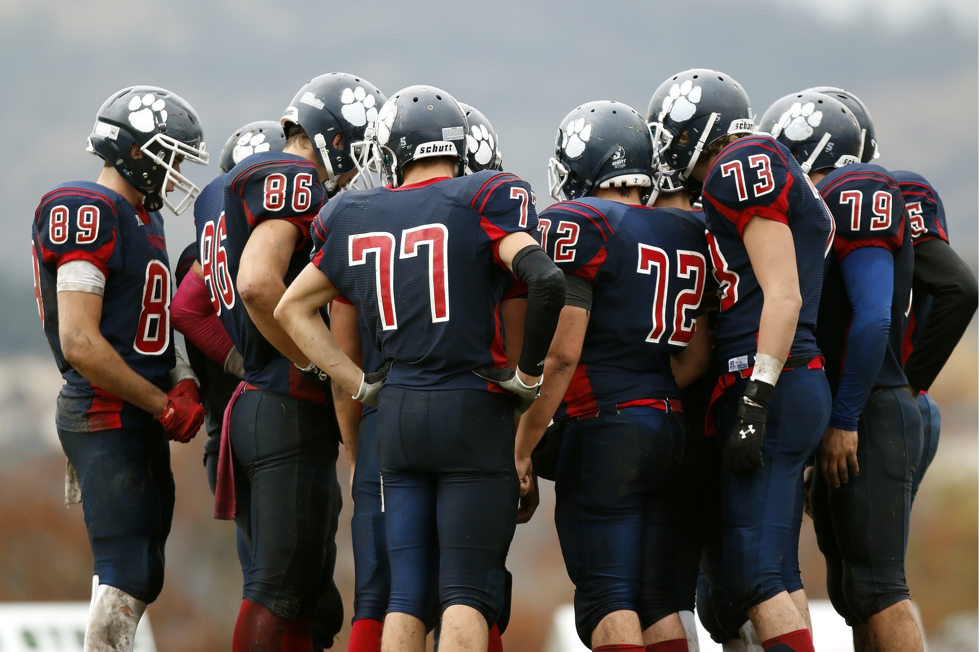 League Management 15 group of highschool football players standing in a huddle